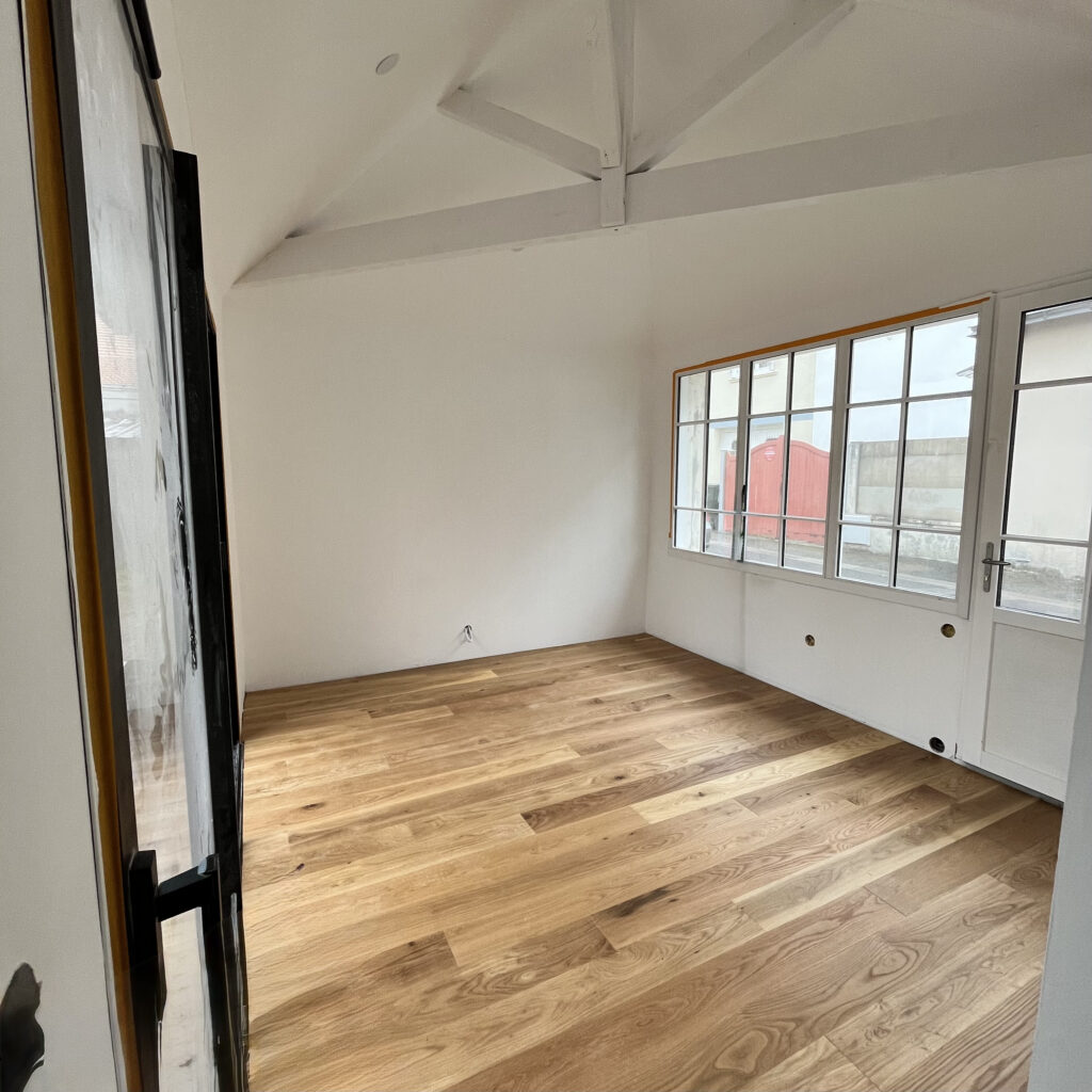 Pose collée de parquet en chêne massif dans une pièce à La Baule